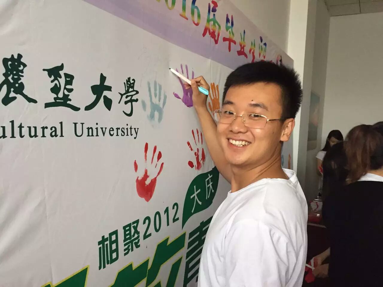毕业生在公司精心制作的签名墙上留念.jpg